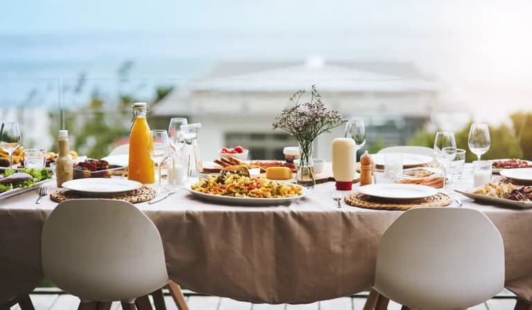 An outdoor table set with food and drink